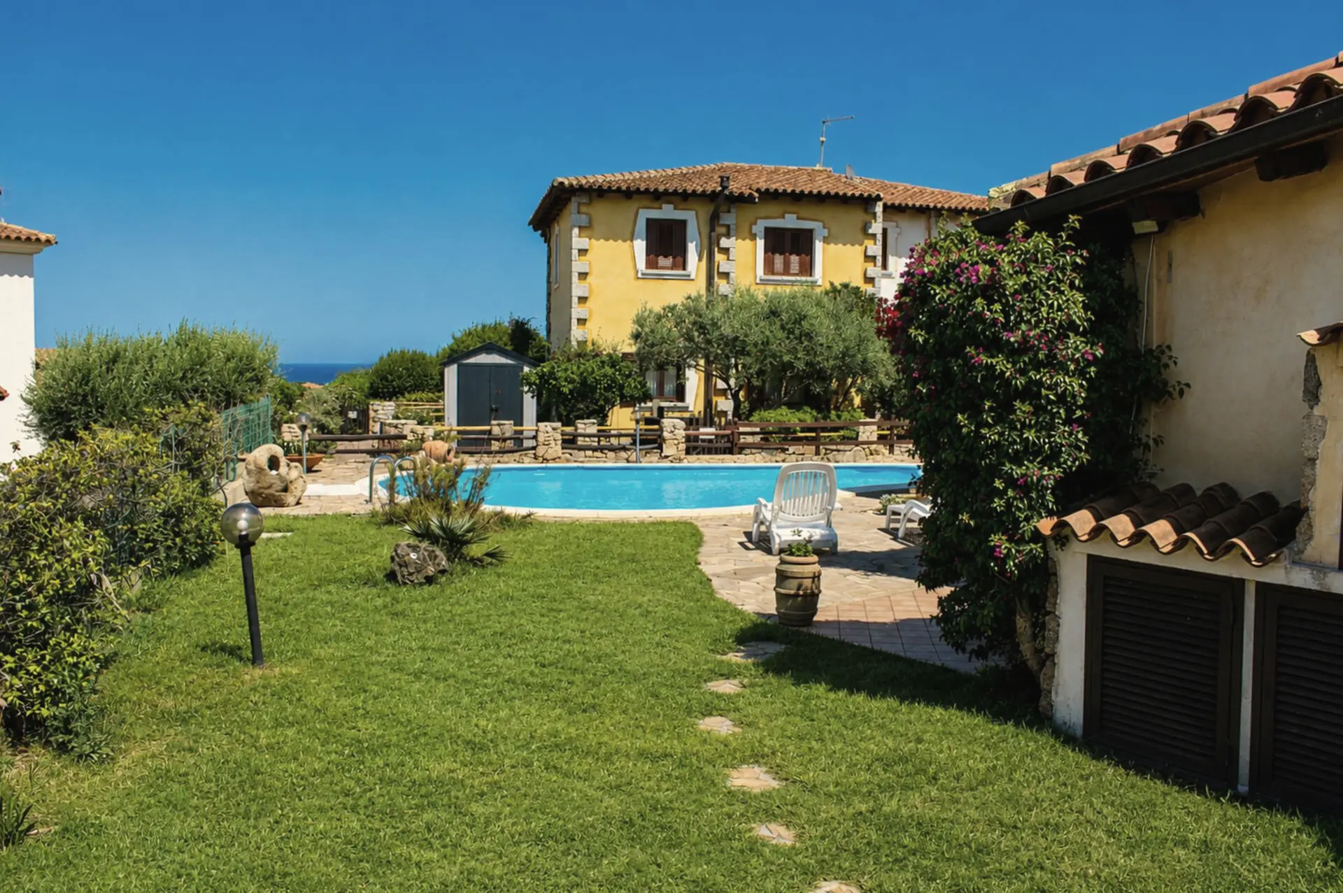 Il giardino verso la piscina, con una striscia di mare all’orizzonte