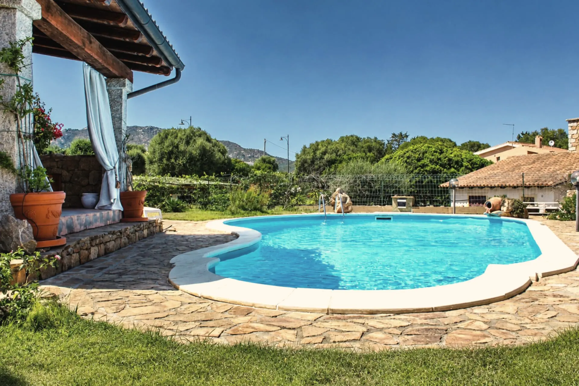 La piscina con il prato e le colline sullo sfondo